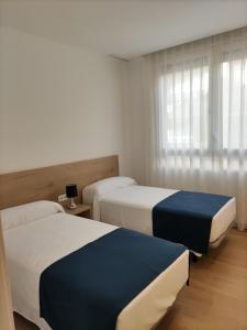 pokój hotelowy z dwoma łóżkami i oknem w obiekcie Iberflat Apartamentos Trinidad w mieście Castellón de la Plana