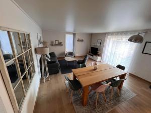 een woonkamer met een houten tafel en stoelen bij Maison d'Alice - avec SPA in Bayeux