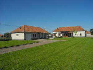 ein Haus mit grünem Rasen neben einem Gebäude in der Unterkunft Het Herenhuis in Poroszló