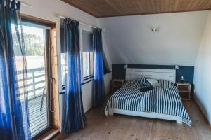 a bedroom with a bed and a large window at Tiiupesa Guest House in Hellamaa