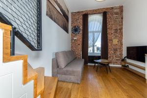 a living room with a chair and a brick wall at Urban Two-Level Apartments 13 in Tallinn