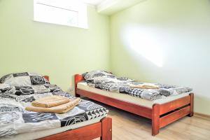 2 Einzelbetten in einem Zimmer mit Fenster in der Unterkunft Farma Serock in Serock