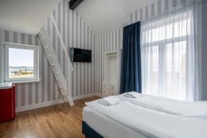 sypialnia z 2 łóżkami, drabiną i oknem w obiekcie W Starym Porcie - pokój z widokiem na Zalew Wiślany balkonem i antresolą w mieście Krynica Morska