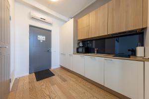 a kitchen with white cabinets and a blue door at Cozy Studio Apartments 47 in Tallinn