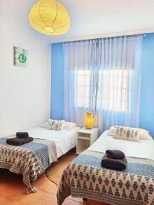2 camas en una habitación con paredes azules en villa tyna, en Playa Blanca
