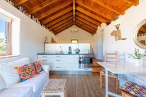 a living room with a white couch and a kitchen at Finca Las Nuevas Casa Sofia in Alora