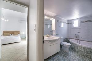 a bathroom with a tub and a sink and a toilet at Panos Villa Asteras in Isterni +90 photos