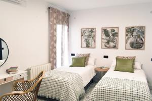 sypialnia z 2 łóżkami, stołem i krzesłami w obiekcie Casa Rural La Lerena w mieście Casar de Cáceres