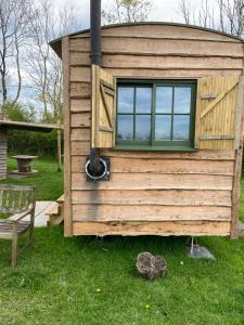 a tiny house with a window and a bench at Bryn Parc in Llandysul