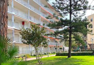 a apartment building with a pine tree in front of it at Apartamentos Hesperia Palmyra in Salou