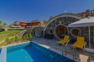 a villa with a swimming pool and a house at Maison Green Hill in Antalya