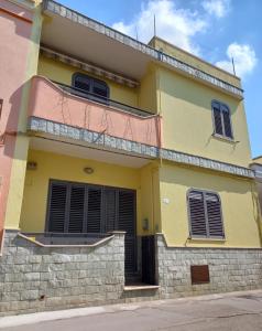 um edifício amarelo e rosa com uma varanda em Pensiero di mare em Taurisano