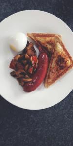 un plato blanco con dos rodajas de tostadas y una cuchara en Shalakwe Hills-Inn B&B Kasane, en Kasane