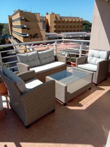 un gruppo di sedie e tavoli in vimini sul tetto di E&C Suites Roma a Lido di Ostia