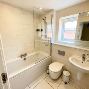 a bathroom with a shower toilet and a sink at Karuna House in Norwich