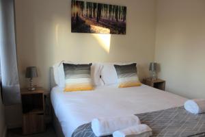 sypialnia z dużym białym łóżkiem z 2 stolikami nocnymi w obiekcie Karuna House w mieście Norwich