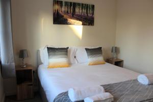 a bedroom with a large white bed with two night stands at Karuna House in Norwich