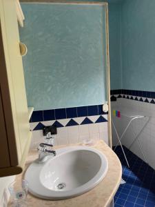 a bathroom with a white sink and blue tiles at Lake Iseo - Gli ulivi 1 in Sulzano