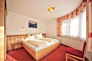 pokój hotelowy z łóżkiem i oknem w obiekcie Appartements Plattlerhof w mieście Serfaus