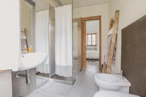 uma casa de banho com um WC, um lavatório e um chuveiro em Relax em Borgosesia