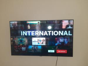a flat screen tv on a wall with the word international at Sandanski city center apartment in Sandanski