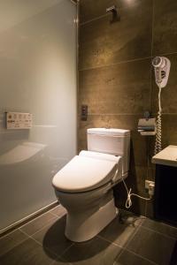 een badkamer met een toilet en een telefoon aan de muur bij City Hotel in Taipei
