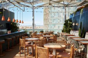 a restaurant with tables and chairs and a view of the city at The Hoxton, Poblenou in Barcelona