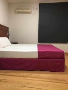 sypialnia z łóżkiem z fioletowo-białą pościelą w obiekcie KubiK HOTEL w mieście Cáceres