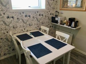 a kitchen with a table and chairs in a room at Heloíse`s accommodation in Fredvang