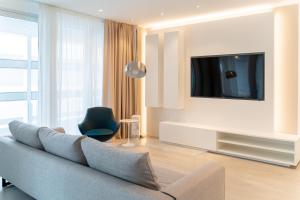 uma sala de estar com um sofá e uma televisão em PLAYA DORADA em Lido di Jesolo