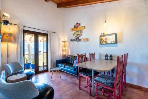 a dining room with a table and chairs and a couch at Finca Las Nuevas Casa Maria Arriba in Alora