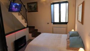 1 dormitorio con 1 cama, TV y escaleras en Villetta Incanto relax, en Cava deʼ Tirreni