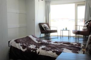 a bedroom with a bed and two chairs and a window at Tiny Cottage 2 in Drijber