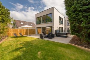 a white house with a patio and a yard at Newly Renovated early 19th Century Cottage with Hot-Tub in Musselburgh