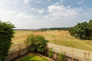 a view of a field with a fence and trees at Newly Renovated early 19th Century Cottage with Hot-Tub in Musselburgh