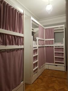 a walk in closet with pink curtains and shelves at Bulgakoff in Kyiv
