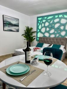 einen weißen Tisch mit einem Glas Wein drauf in der Unterkunft Bakuba - Studio pe plaja cu vedere la mare & loc parcare gratis in Mamaia Nord – Năvodari