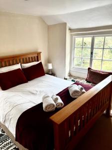 a bedroom with a large bed with towels on it at 4 St Richard’s Cottages in Fittleworth