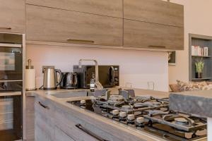 a kitchen with a stove top oven next to a sink at Bohemian luxury accommodation in the heart Edinburghs Leith district in Edinburgh