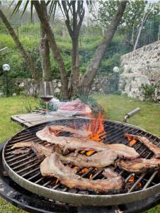 a bunch of meat on a grill with a glass of wine at Casaventre in Vietri sul Mare