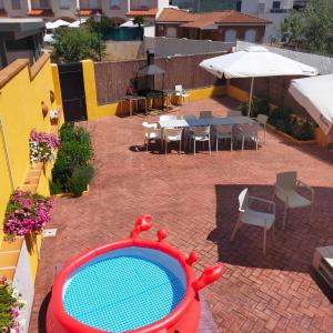 una piscina en medio de un patio con mesas y sillas en Ideal FAMILIAS hasta 15 Personas en San Martín de Valdeiglesias Madrid en San Martín de Valdeiglesias