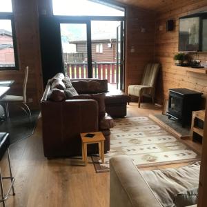 a living room with a couch and a stove at Lomond Lodge in Rowardennan