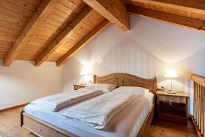 a large bed in a room with wooden ceilings at Peintenhof Typ B in Sand in Taufers