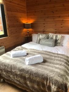 a bedroom with a bed with two towels on it at Lomond Lodge in Rowardennan