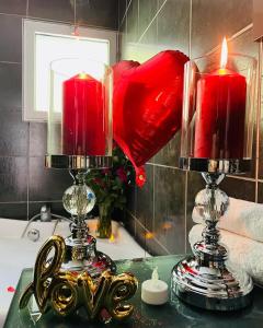 two candles on top of a table with a mirror at Superbe Appartement avec vue sur le Lac du Bourget in Tresserves