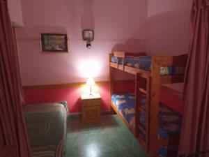 a small room with two bunk beds and a lamp at Departamento 2 ambientes PB a metros del mar in Mar de Ajó