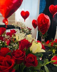 a bouquet of red roses and red heart balloons at Superbe Appartement avec vue sur le Lac du Bourget in Tresserves