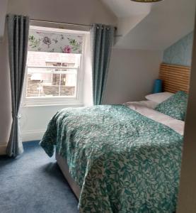 sypialnia z łóżkiem i oknem w obiekcie The Lakes B and B w mieście Ambleside