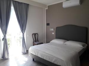 a bedroom with a bed and a large window at Hotel Villa Bonelli in Fiesole