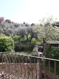 widok na ogród z drzewami i ogrodzeniem w obiekcie Hotel Villa Bonelli w mieście Fiesole